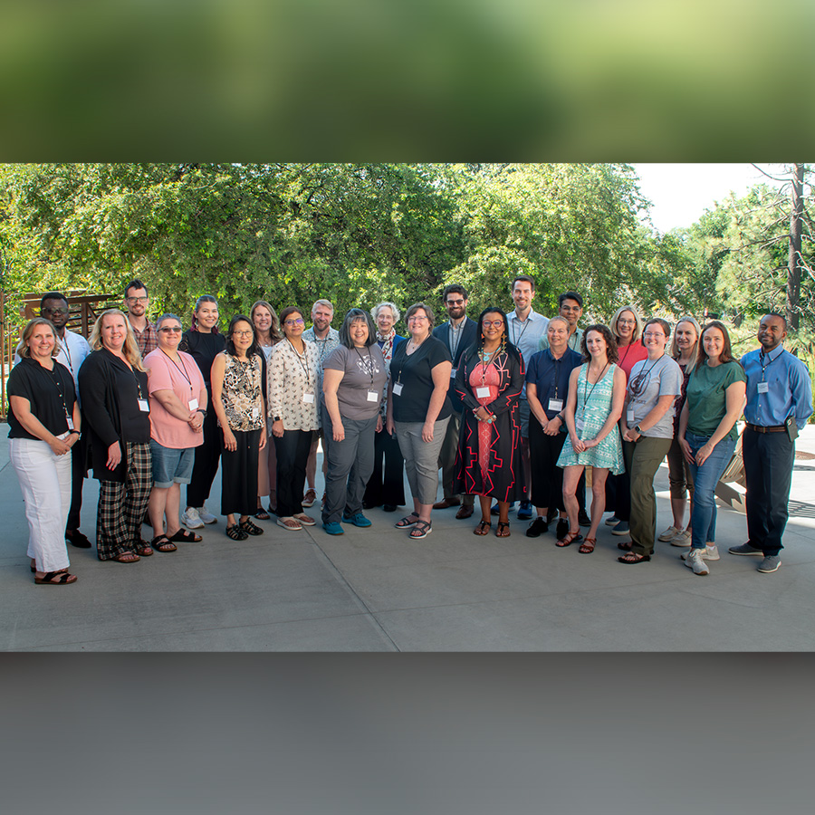 Summer institute participants and instructors pose outside for a group photo.